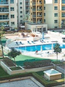 a large swimming pool in front of a building at Cozy Chic Studio with Balcony The Greens Dubai in Dubai