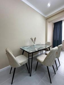 a dining room with a glass table and chairs at Your home away from home. in Bishkek +9 photos