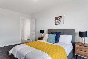 a bedroom with a large bed with a yellow blanket at Stylish 1 bed flat in Central Birmingham in Birmingham
