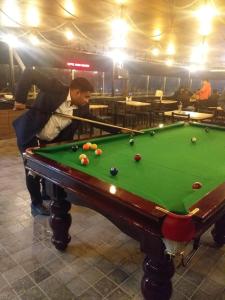 a man playing a game of pool on a pool table at HOTEL GRAND PALACE & BANQUET in Siliguri