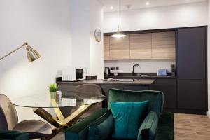 a kitchen with a glass table and green chairs at Cosy 1 Bedroom Apartment in Bolton in Bolton