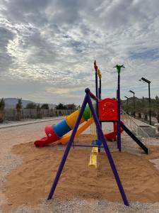 a playground with a slide in the sand at Alreef farm in Ras al Khaimah