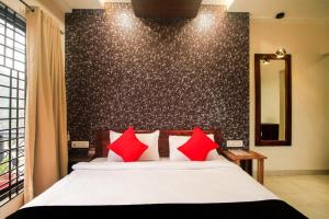 ein Schlafzimmer mit einem Bett mit roten Kissen in der Unterkunft HOTEL GRAND PALACE & BANQUET in Shiliguri