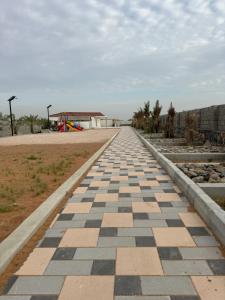 a brick road with a playground in the distance at Alreef farm in Ras al Khaimah