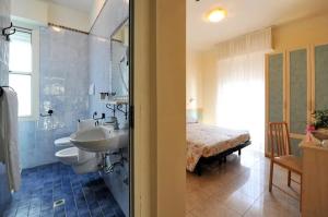 La salle de bains est pourvue d'un lavabo et d'un lit. dans l'établissement Hotel Anita, à Gatteo a Mare