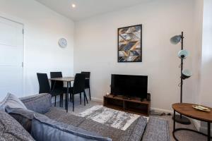 ein Wohnzimmer mit einem Sofa und einem TV in der Unterkunft Modern 2 Bedroom Apartment in Bolton in Bolton