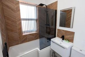 a bathroom with a sink and a shower and a mirror at Modern 2 Bedroom Apartment in Bolton in Bolton