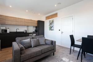 ein Wohnzimmer mit einem Sofa und einer Küche in der Unterkunft Modern 2 Bedroom Apartment in Bolton in Bolton