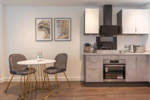 a kitchen with a table and two chairs and a counter at Luxurious 1 bed apartment with free parking in York