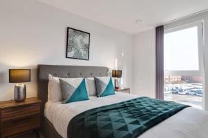 a bedroom with a large bed with blue pillows at Beautiful 2 Bed Apartment in a Converted Mill in Leeds