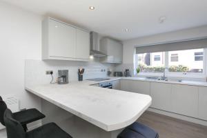 uma cozinha branca com uma grande bancada branca em Stunning 2 Bedroom Apartment in Wallasey em Wallasey