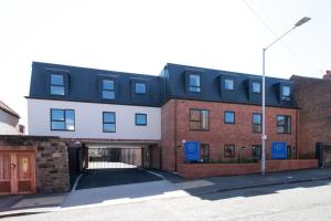 a large brick building with a parking garage at Stunning 2 Bedroom Apartment in Wallasey in Wallasey