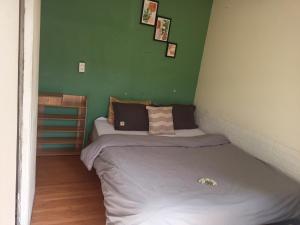 two beds in a room with a green wall at Dalat Inn ez home in Da Lat
