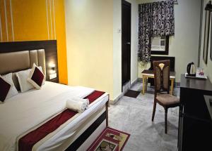 een slaapkamer met een bed, een bureau en een stoel bij STAYMAKER The Altira in Jamshedpur