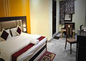 a hotel room with a large bed and a chair at STAYMAKER The Altira in Jamshedpur