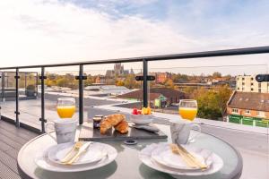 una mesa con comida y vasos de zumo de naranja en el balcón en Amazing 2 bed Apartment with Roof Terrace in the heart of York, en York