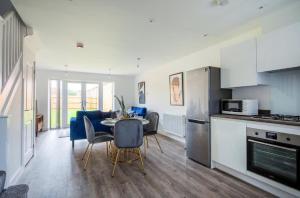 uma cozinha e sala de estar com mesa e cadeiras em Lovely brand new 3 bedroom city centre house with garden em Derby
