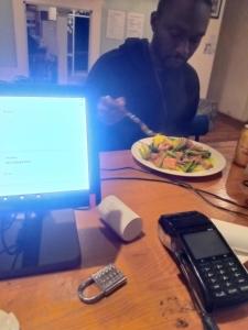 Dalat Inn ez home في دالات: رجل يجلس على طاولة مع طبق من الطعام