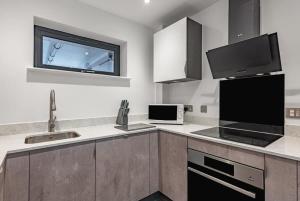 a kitchen with a sink and a microwave and a tv at Amazing 2 bed apartment in York's city centre in York