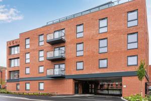 a large red brick building with a balcony at Amazing 2 bed apartment in York's city centre in York