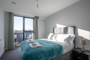 a bedroom with a bed and a large window at Superb 2 Bedroom Aparttment in Central Birmingham in Birmingham