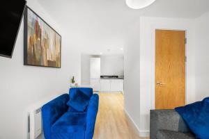a living room with a blue couch and a wooden floor at A Lovely 2 Bedroom Apartment in the Heart of Preston in Preston