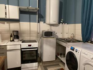 a kitchen with a washing machine and a microwave at Studio du Valvion in Beauquesne