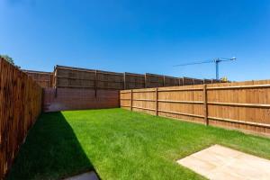 a backyard with a fence and green grass at Modern 3 Bedroom House in Central Derby in Derby