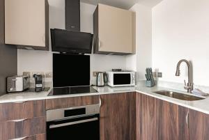 uma cozinha com um lavatório e um micro-ondas em Stunning Modern 2 Bedroom Apartment in York em York