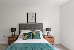 um quarto com uma cama grande e almofadas verdes em Stunning Modern 2 Bedroom Apartment in York em York