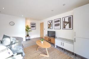 A Stylish Apartment with Parking in Preston في بريستون: غرفة معيشة مع أريكة وطاولة