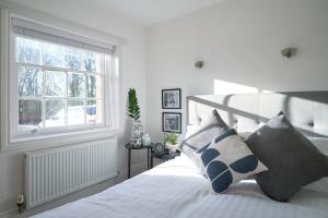 A Stylish Apartment with Parking in Preston في بريستون: غرفة نوم بسرير ومخدات ونافذة