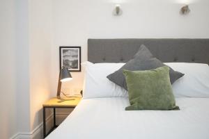 a bedroom with a white bed with a green pillow at Lovely 2 Bedroom Apartment in Preston in Preston