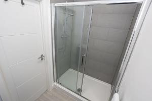 a shower with a glass door in a bathroom at Contemporary Bolton Apartment in Central Location in Bolton
