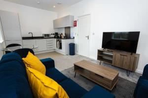 a living room with a blue couch and a tv at Modern 1BR Bolton Apartment in Central Location in Bolton