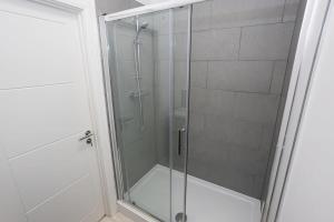 y baño con ducha y puerta de cristal. en Modern 1BR Bolton Apartment in Central Location en Bolton