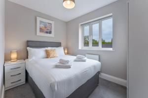a bedroom with a white bed and a window at Spacious 3 Bedroom House with Garden in Birmingham in Birmingham