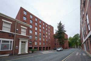 an empty city street with buildings and a car at Fabulous 1 Bedroom Apartment in Central Preston in Preston