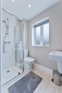 a bathroom with a shower and a toilet and a sink at Spacious 3 Bedroom House with Garden in Birmingham in Birmingham