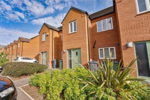 a row of brick houses with a car parked outside at Spacious 3 Bedroom House with Garden in Birmingham in Birmingham