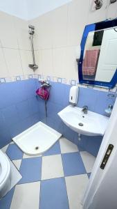 ein blau-weißes Bad mit einem Waschbecken und einem Spiegel in der Unterkunft Gerea's Holiday House in Durrës + 22 Fotos