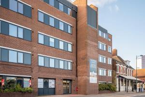 a red brick building on a city street at Modern 1 Bedroom Apartment in Central Eastleigh in Eastleigh