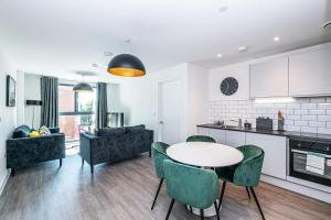 a kitchen and living room with a table and chairs at Stylish 2 Bedroom Apartment by Old Trafford in Manchester