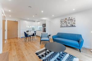 a living room with a blue couch and a table at Lovely 1 Bedroom Apartment in Central Location in Birmingham