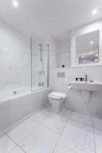 a white bathroom with a toilet and a sink at Lovely 1 Bedroom Apartment in Central Location in Birmingham