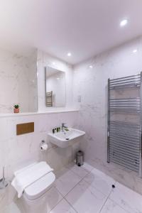 a white bathroom with a sink and a toilet at Lovely 1 Bedroom Apartment in Central Location in Birmingham