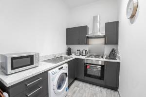 a kitchen with a microwave oven and a washer at Modern 1 Bedroom Apartment in Dudley in Brierley Hill