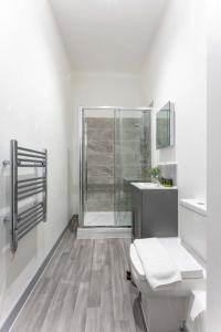 a white bathroom with a shower and a toilet at Modern 1 Bedroom Apartment in Dudley in Brierley Hill