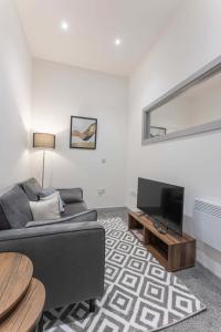 a living room with a couch and a flat screen tv at Modern 1 Bedroom Apartment in Dudley in Brierley Hill