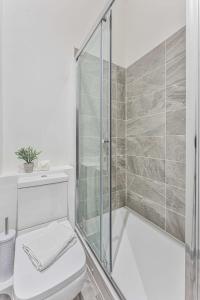 a white bathroom with a shower and a toilet at Contemporary 1 Bedroom Apartment in Dudley in Brierley Hill